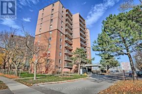 Mississauga (Applewood) condo for rent - A tall brick apartment building with a sign that says "REAL BROKER ONTARIO LTD, Brokerage" in front of it.