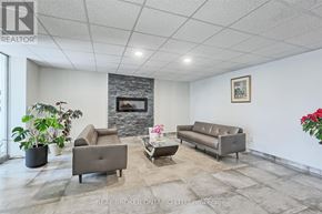 Mississauga (Applewood) condo for rent - A living room with grey couches and a stone fireplace.