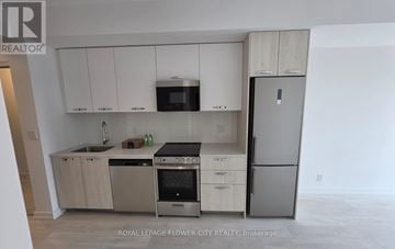 Hamilton (Corktown) condo for rent - A kitchen with white cabinets and stainless steel appliances.