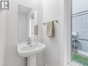 Stratford townhouse for rent - A white sink in a bathroom with a mirror and towel rack.