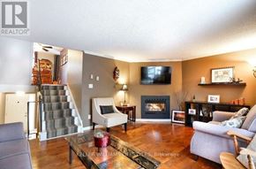 London South (South R) house for rent - A living room with a grey couch, a coffee table, a fireplace, and a television.