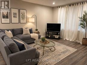 London North (North K) apartment for rent - A living room with a grey couch, a glass coffee table, and a flat screen TV.