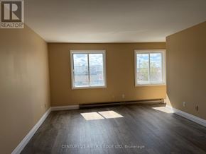 Prescott apartment for rent - A spacious room with two windows and wooden flooring.