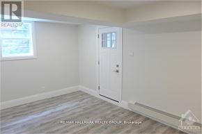 Ottawa multi-family for rent - A room with a door and a window, with a REALTOR sign on the wall.