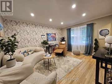 Ottawa apartment for rent - A living room with a couch, a chair, a table, and a painting on the wall.