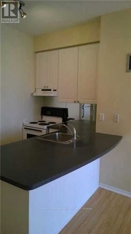 Toronto (Church-Yonge Corridor) condo for rent - A kitchen with a black counter top and white cabinets.