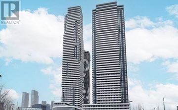 Vaughan (Vaughan Corporate Centre) condo for rent - Two tall buildings with a blue sky and clouds in the background.