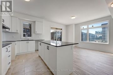 Brampton (Northwest Brampton) townhouse for rent - A kitchen with white cabinets and a black countertop.