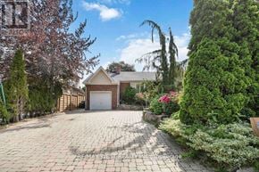 Toronto (Maple Leaf) apartment for rent - A house with a driveway surrounded by greenery and a sign that says RE/MAX West Realty Inc. Brokerage.