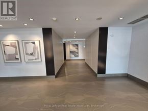 Mississauga (Clarkson) condo for rent - A hallway with marble floors and two framed pictures on the wall.