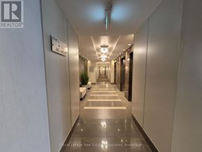 Mississauga (Clarkson) condo for rent - A long, narrow hallway with a plant on the left and a sign on the wall.