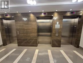 Mississauga (Clarkson) condo for rent - Three elevators in a hallway with a sign that says "REALTOR" on the wall.