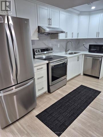 Brampton (Credit Valley) apartment for rent - A modern kitchen with a stainless steel refrigerator and white cabinets.