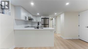 Kitchener apartment for rent - A modern kitchen with white cabinets and a stainless steel refrigerator.