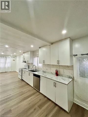 Brantford apartment for rent - A kitchen with white cabinets and a marble countertop.