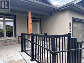 Brockville apartment for rent - A black metal fence in front of a house with a garage door.