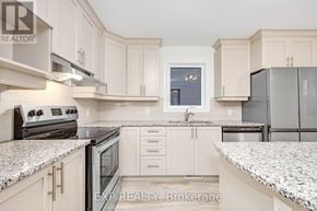 Clarence-Rockland townhouse for rent - A kitchen with white cabinets and granite countertops.