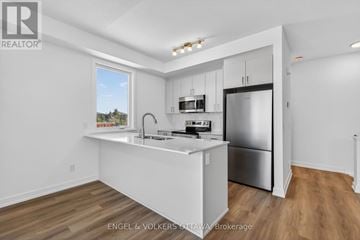 Ottawa townhouse for rent - A kitchen with white cabinets and a stainless steel refrigerator.