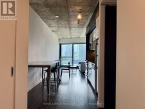 Toronto (Moss Park) condo for rent - A room with a bar and a window overlooking a city.