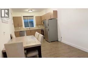 Burnaby apartment for rent - A kitchen with a table and chairs and a refrigerator.