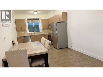 Burnaby apartment for rent - A kitchen with a table and chairs and a refrigerator.