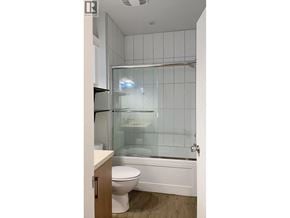 Burnaby apartment for rent - A white toilet sits next to a glass shower stall in a bathroom.