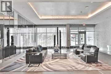 Oakville condo for rent - A large, modern living room with a long couch and a large rug.