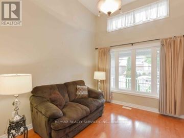 Brampton (Bramalea North Industrial) apartment for rent - A brown couch sits in a living room with a lamp and a window.
