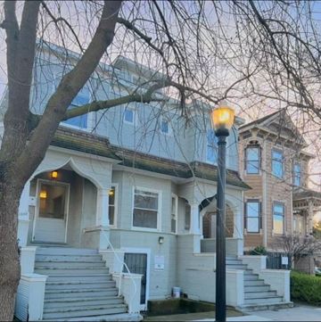 Sacramento apartment for rent - A house with a grey front and a tree in front of it.