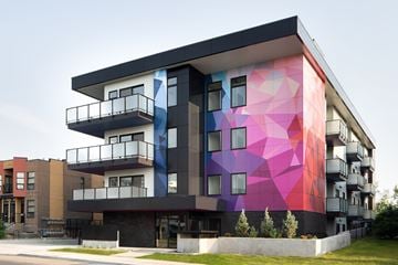 Calgary apartment for rent - A modern building with a colorful mural on the side.