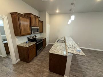 Temple townhouse for rent - A kitchen with granite countertops and wooden cabinets.