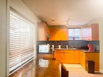 Surrey apartment for rent - A kitchen with wooden cabinets and a white microwave.