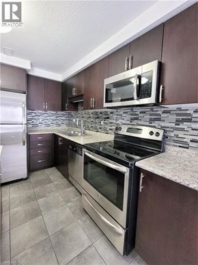 Kitchener townhouse for rent - A kitchen with a refrigerator, microwave, oven, and stove.