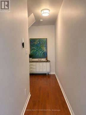 Toronto (Dovercourt-Wallace Emerson-Junction) multi-family for rent - A long hallway with a cabinet and a painting on the wall.