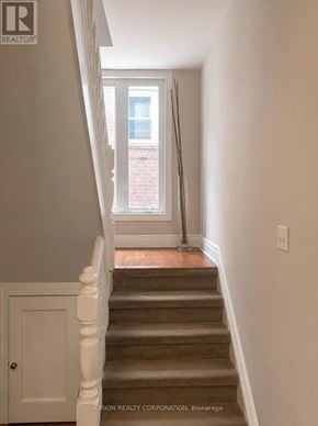 Toronto (Dovercourt-Wallace Emerson-Junction) multi-family for rent - A staircase with a white railing and a brown carpet.