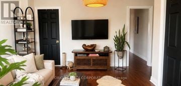 Toronto (Dovercourt-Wallace Emerson-Junction) multi-family for rent - A living room with a white couch and a black door.