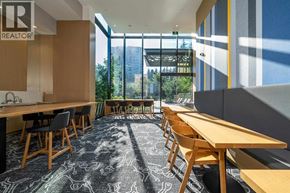 Vancouver apartment for rent - A conference room with a long table and chairs, a carpet with a pattern, and a window showing an outdoor view.