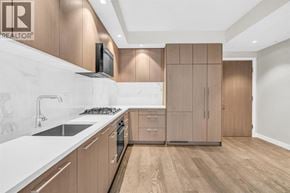 Vancouver apartment for rent - A modern kitchen with wooden cabinets and a white countertop.