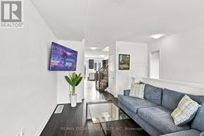 Lincoln (Beamsville) townhouse for rent - A living room with a grey couch and a flat screen TV mounted on the wall.