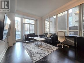 Toronto (Bay Street Corridor) condo for rent - A modern kitchen with dark brown cabinets and a marble countertop.