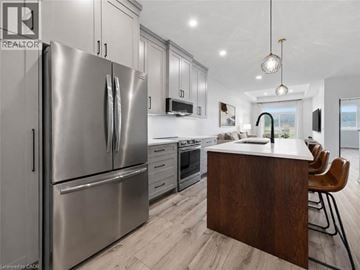 Wellington townhouse for rent - A modern kitchen with a stainless steel refrigerator and wooden island.