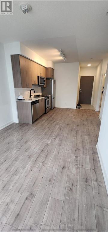Toronto (Weston) condo for rent - A kitchen with wooden floors and a microwave.