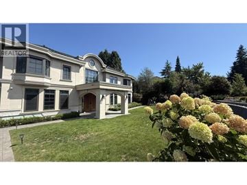 Vancouver apartment for rent - A large house with a lawn and trees in the background.