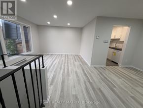 Ottawa townhouse for rent - A room with a balcony and a kitchen area in the background.
