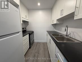 Ottawa townhouse for rent - A kitchen with white cabinets and a black countertop.