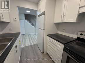Ottawa townhouse for rent - A kitchen with white cabinets and a black stove top oven.