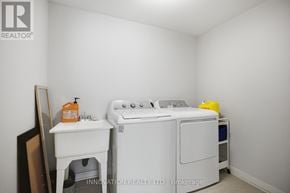 Ottawa townhouse for rent - A white washing machine and ironing board in a small room.