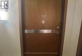 Toronto (Waterfront Communities) condo for rent - A wooden door with a metal handle and a number 3002 on it.