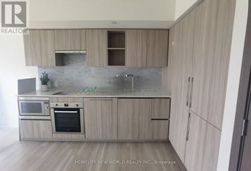 Toronto (Waterfront Communities) condo for rent - A modern kitchen with wooden cabinets and stainless steel appliances.