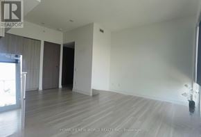 Toronto (Waterfront Communities) condo for rent - A spacious room with wooden flooring and white walls, part of a real estate listing.